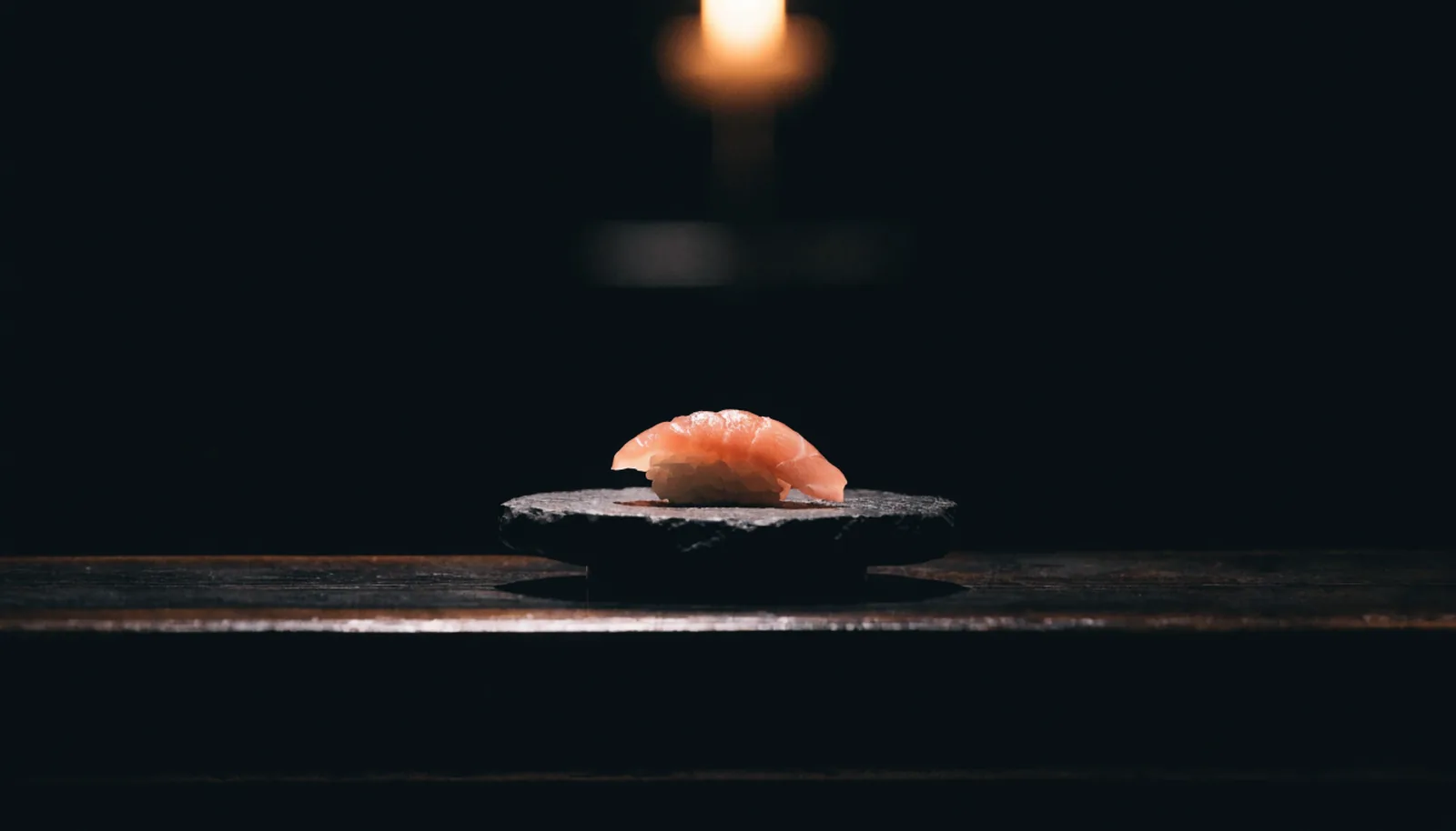 Ein Stück Nigiri auf dunklem Stein